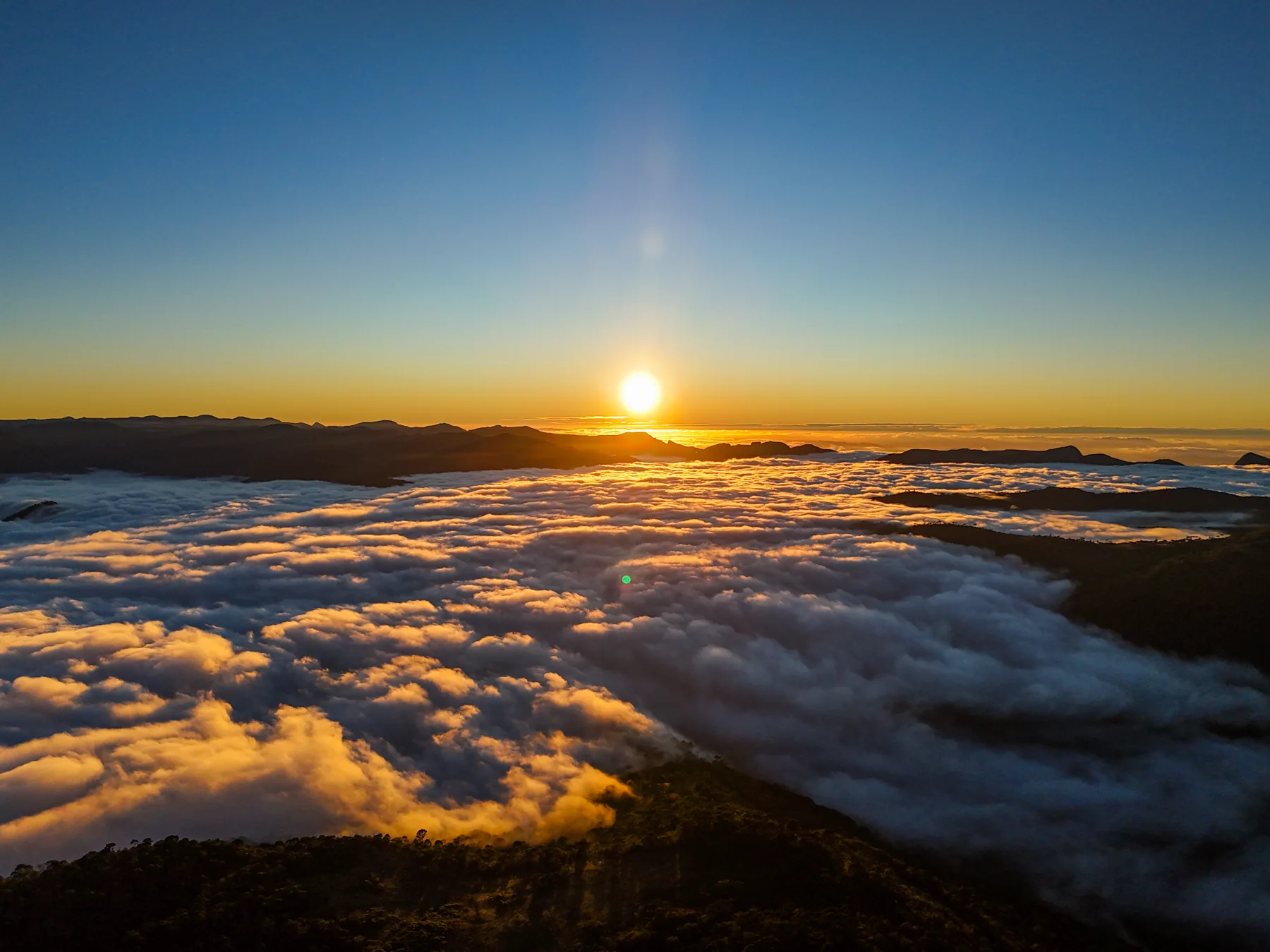 O sol nasce sobre um mar de nuvens que cobre os vales da Serra Catarinense